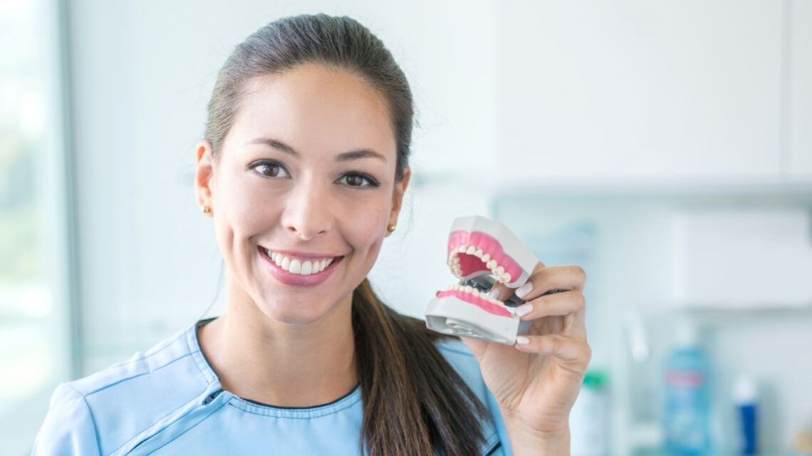 dentist holding a custom fitted dentures