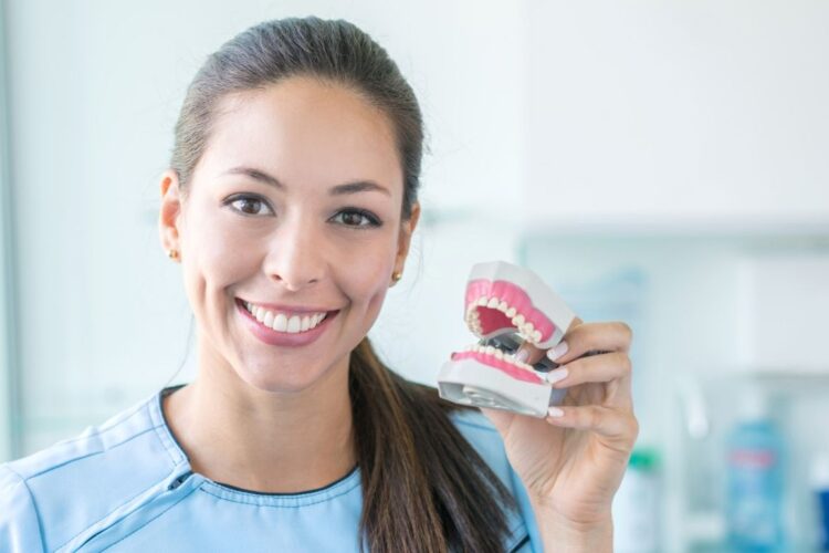 dentist holding a custom fitted dentures